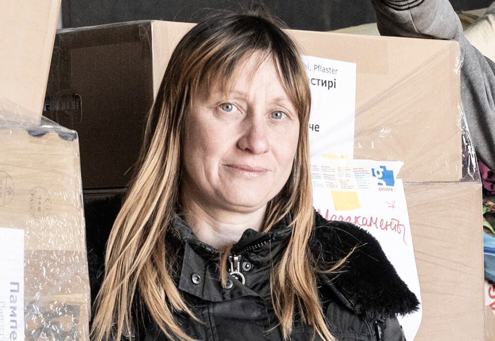Oksana Sgier, Verein Ukraine Hilfe Graubünden, an der ukrainischen Grenze vor vor Schachteln mit Hilfsgütern
